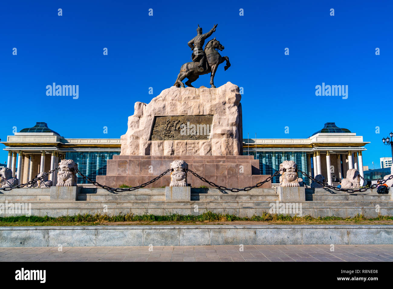 Statue des Mongolischen Revolutionären Helden Sukhbaatar im Sukhbaatar Platz oder Dschingis Khan Square mit dem Parlament im Hintergrund bei Ulaanbaatar Stockfoto