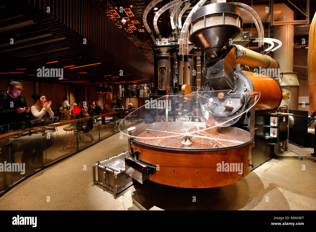 Die Menschen sehen frisch gerösteten Kaffeebohnen aus einem großen Probat Röster Starbucks finden Rösterei New York gießen Stockfoto