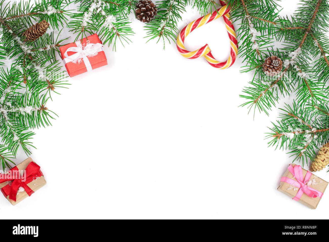 Weihnachten Rahmen der Fir Tree Branch mit Zuckerstangen und Boxen auf weißem Hintergrund mit Kopie Platz für Ihren Text isoliert Stockfoto