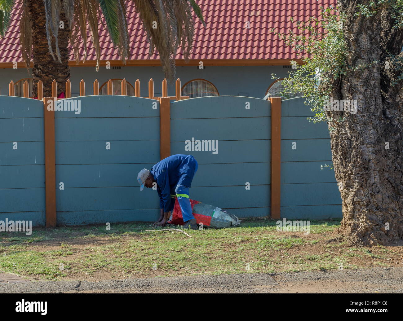 Johannesburg, Südafrika - ein unbekannter Mann in Schwarz funktioniert die manuelle Arbeit in einem Wohngebiet Garten Bild mit Kopie Raum im Querformat. Stockfoto