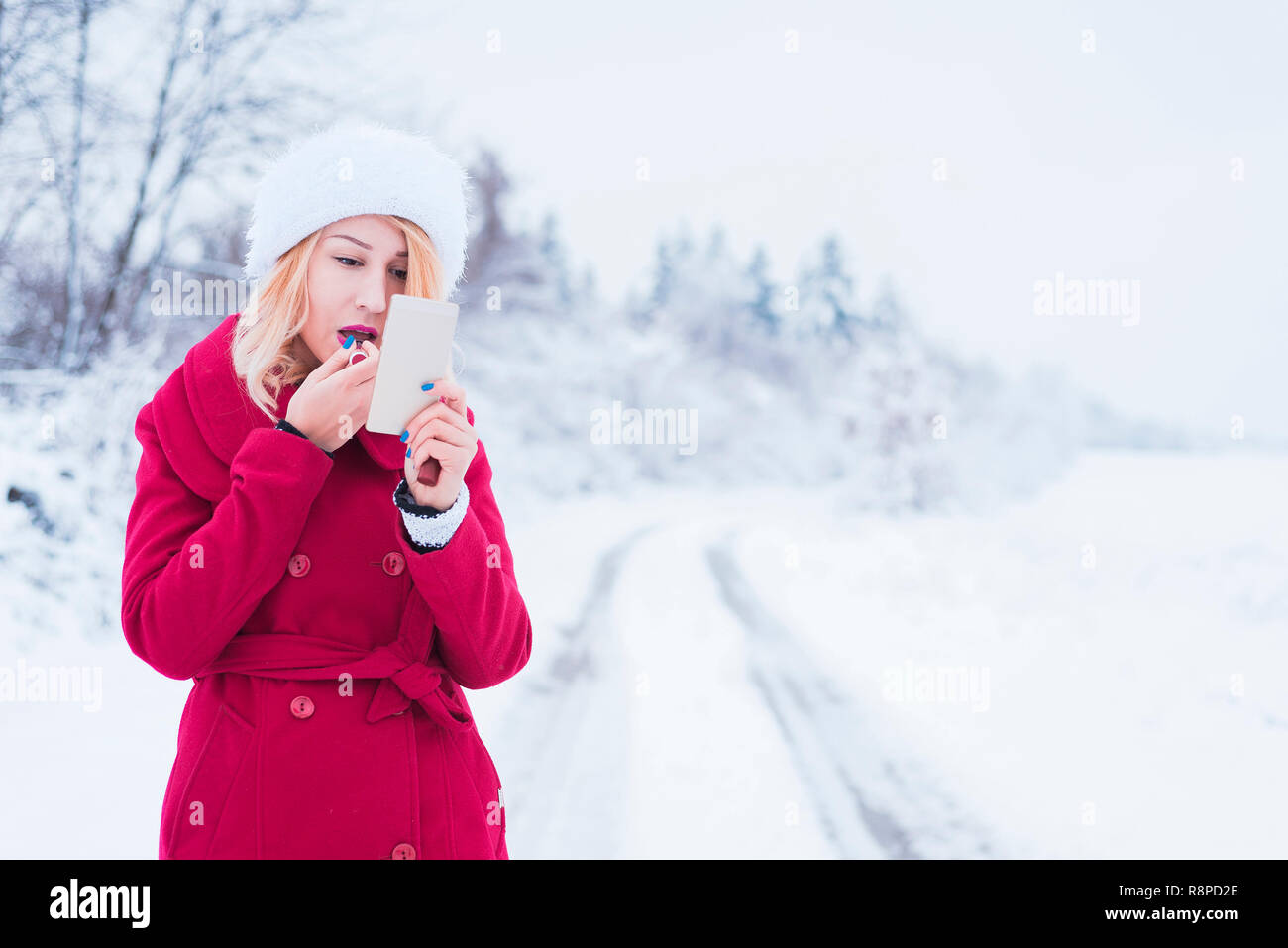 Schöne junge Frau Anwendung Make-up im Winter Stockfoto