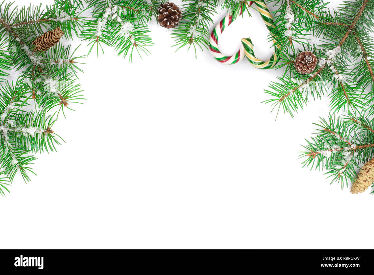 Weihnachten Rahmen der Fir Tree Branch mit Zuckerstangen und Schnee auf weißem Hintergrund mit Kopie Platz für Ihren Text isoliert Stockfoto