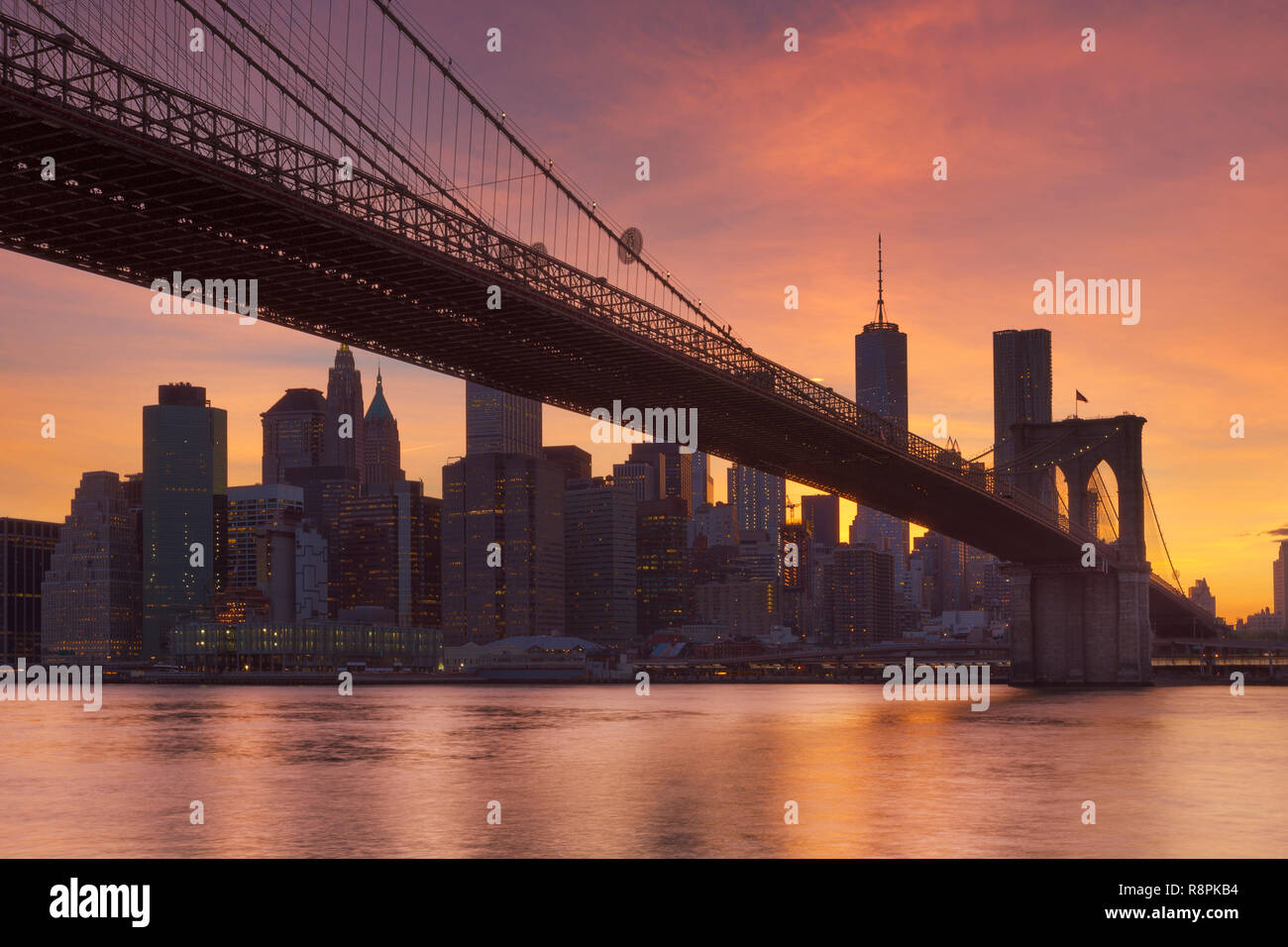 Brooklyn Bridge mit der New Yorker Skyline im Hintergrund, bei Sonnenuntergang fotografiert. Stockfoto