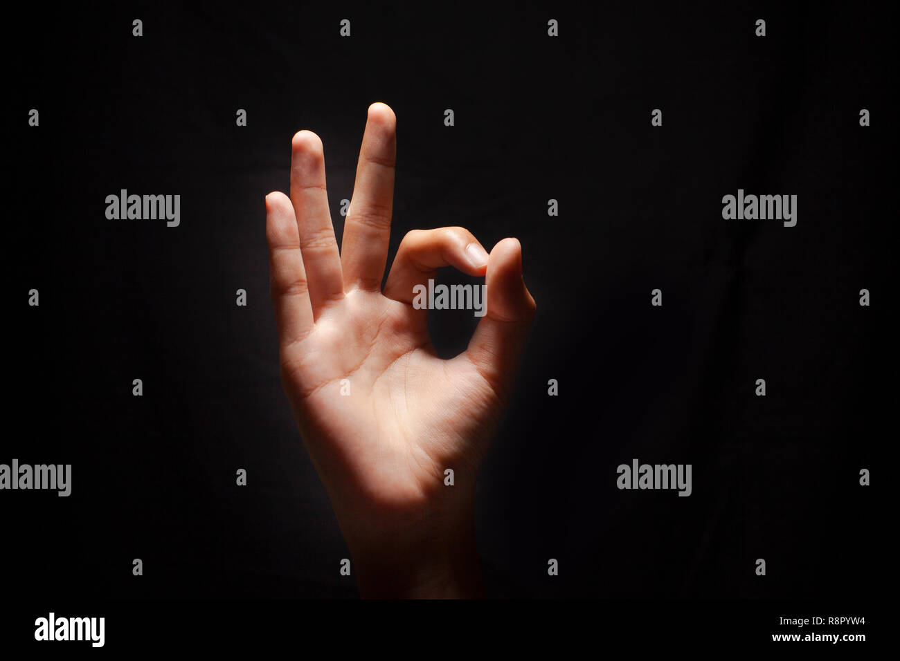 Ok Okay Codierung von Hand auf schwarzem Hintergrund isoliert. Erfolg Symbol mit den Fingern Konzept. Stockfoto