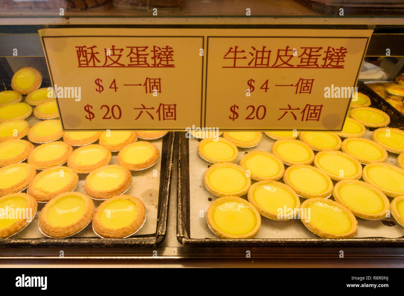 Verschiedene Arten von ei Torten zum Verkauf an die rote Kirsche Bäckerei in Sham Shui Po, Hongkong Stockfoto