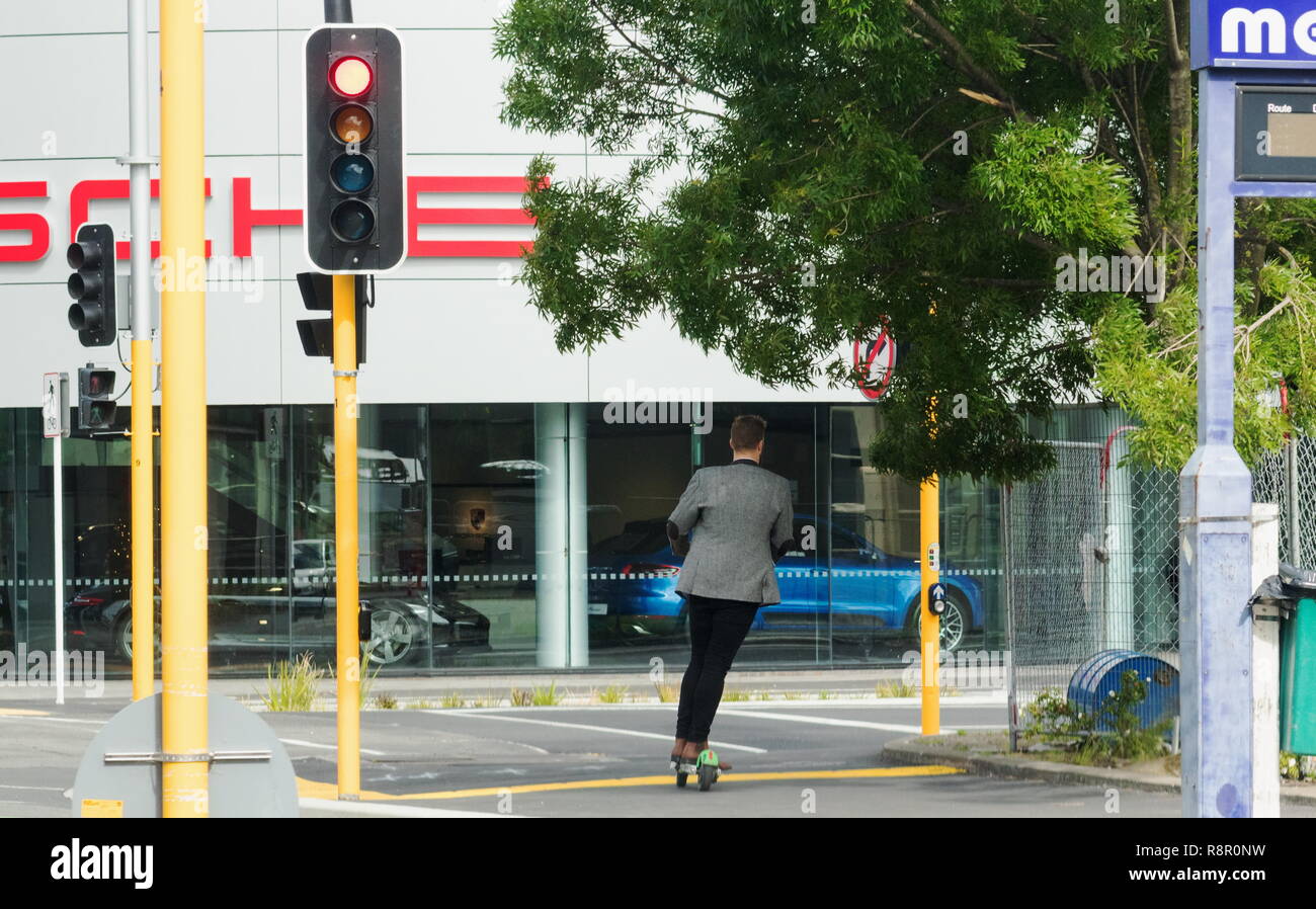 Christchurch, Neuseeland - 1. Dezember 2018: Ein junger Mann scoots um Stadt auf eine elektrische Kalk Roller, ein beliebtes neues Transportmittel gerollt werden, Stockfoto