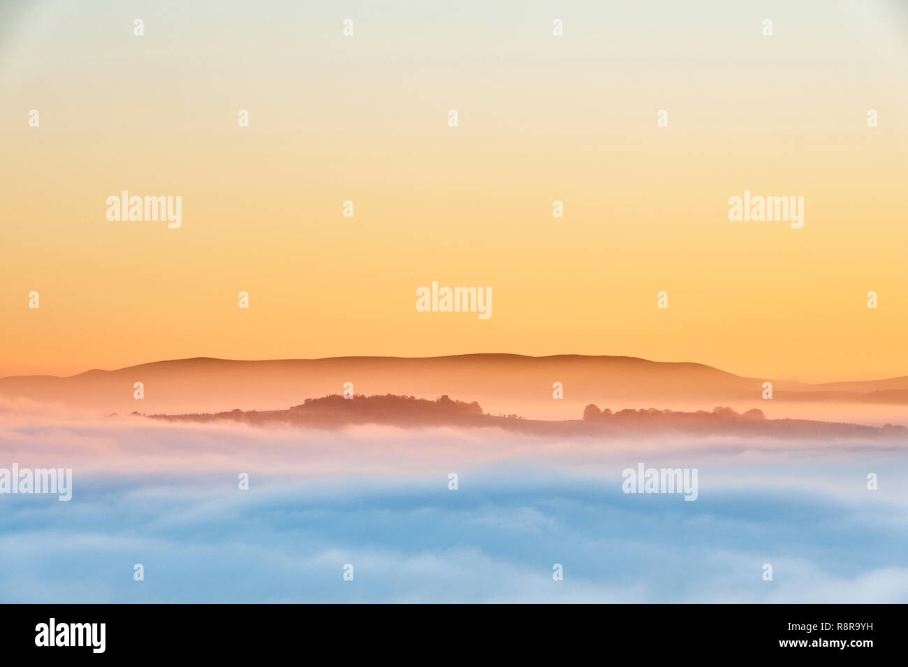 Auf Stonewall Hill in der walisischen Grenze in der Nähe von Knighton, Großbritannien. Abendlicher Blick von Heu Bluff und die Black Mountains, die die Täler mit dichten Nebel gefüllt Stockfoto