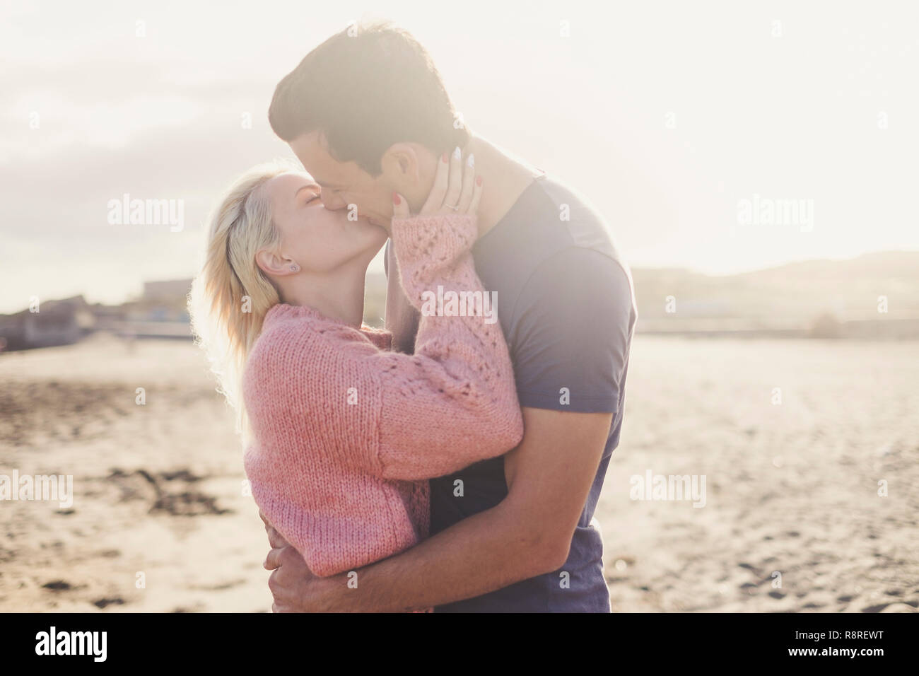 Romantische Kuss für junge Schöne kaukasischen Paar umarmen und lieben Outdoor mit Hintergrundbeleuchtung - Freiheit und Leben für tausendjährigen Menschen genießen - yout Stockfoto