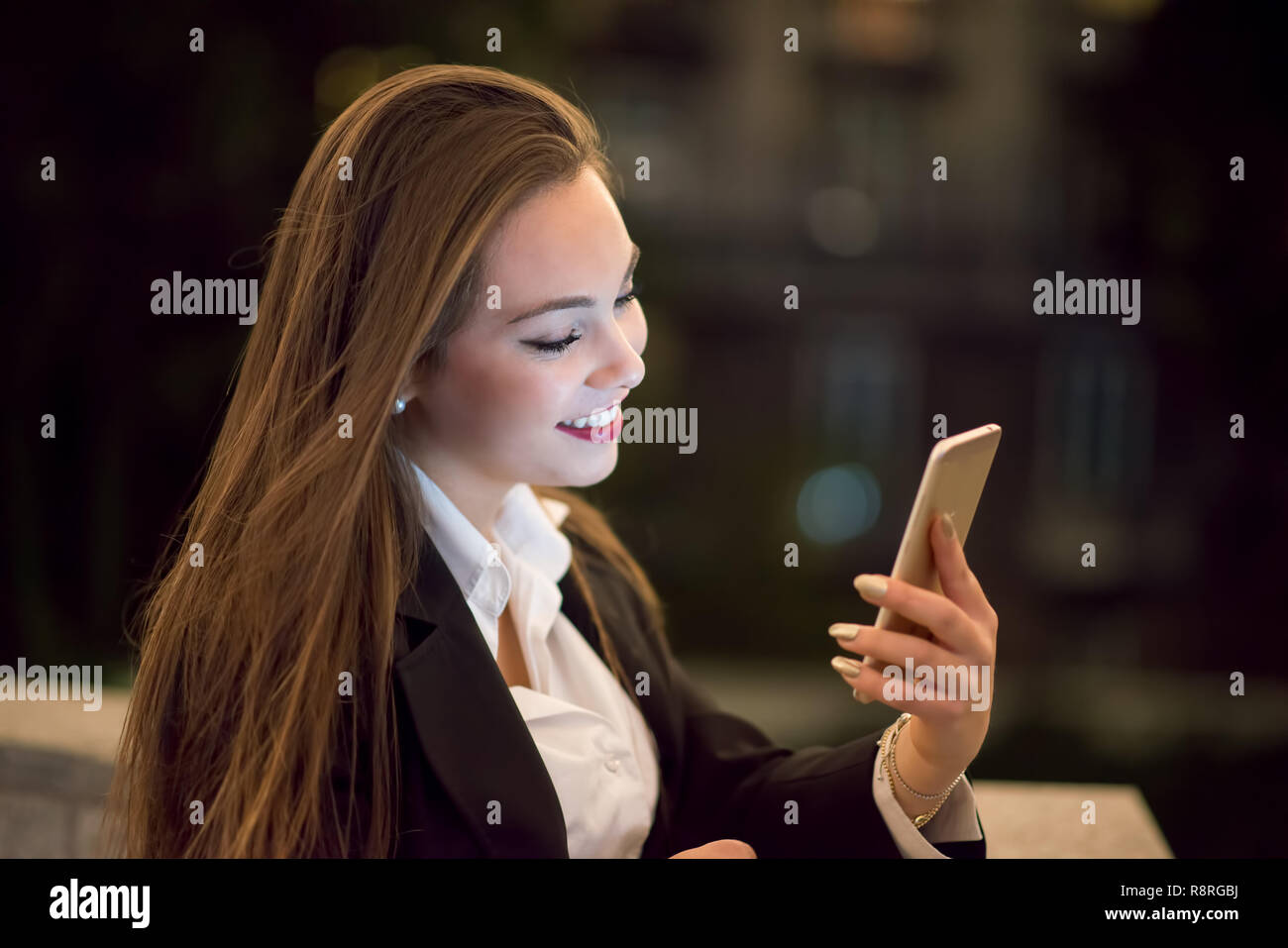 Frau mit der Handys in der Nacht in einer Stadt Stockfoto