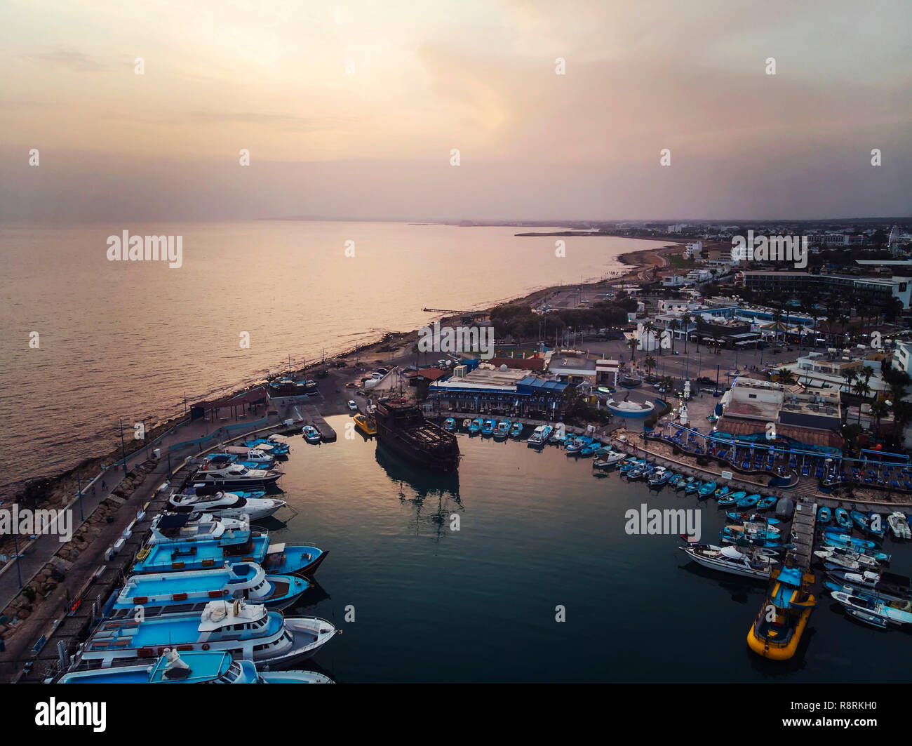 Viele Schiffe sind im Hafen in der Nähe der Ufer auf dem Hintergrund einer schönen Sonnenuntergang. Mediterranen Küste von Zypern, Ayia Napa Stockfoto