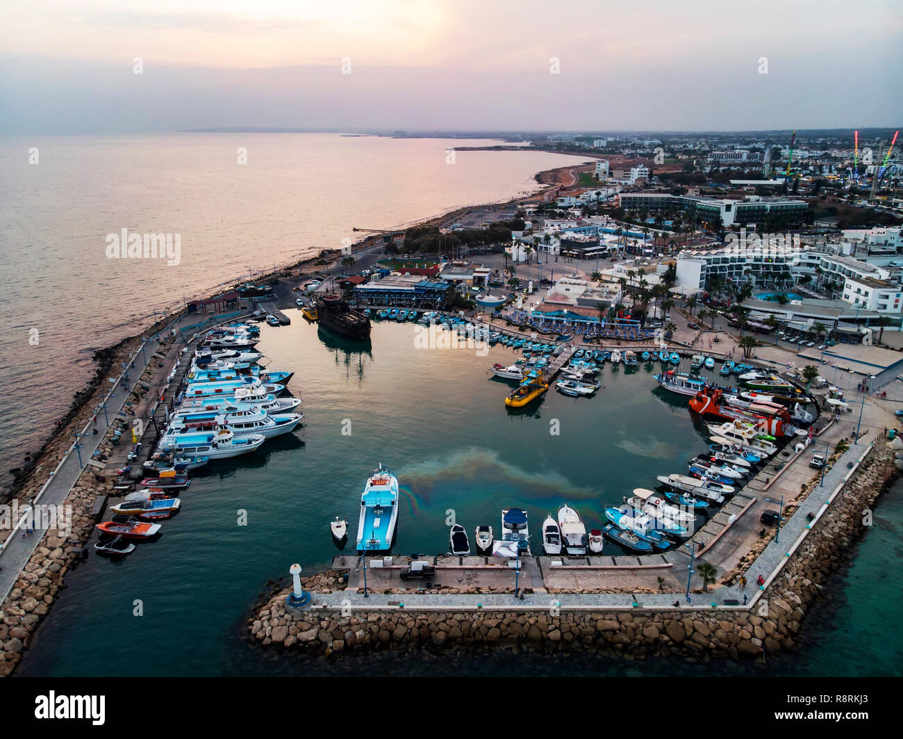 Viele Schiffe sind im Hafen in der Nähe der Ufer auf dem Hintergrund einer schönen Sonnenuntergang. Mediterranen Küste von Zypern, Ayia Napa Stockfoto