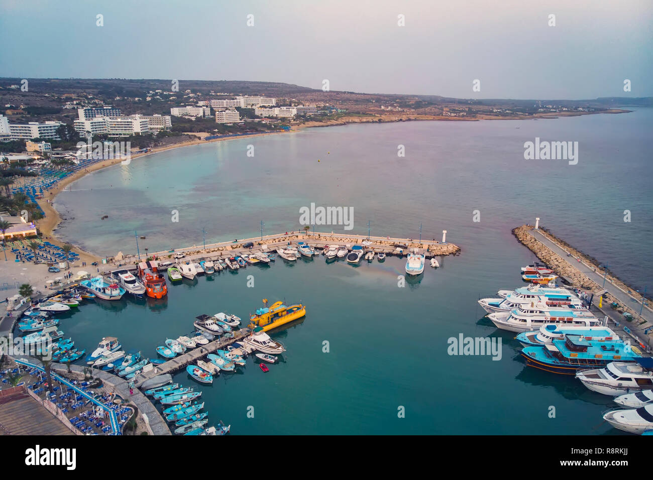 Viele Schiffe sind im Hafen in der Nähe der Küste. Kleine Boote an der Pier im Abendlicht geparkt.. Mediterranen Küste von Zypern, Ayia Napa. Stockfoto
