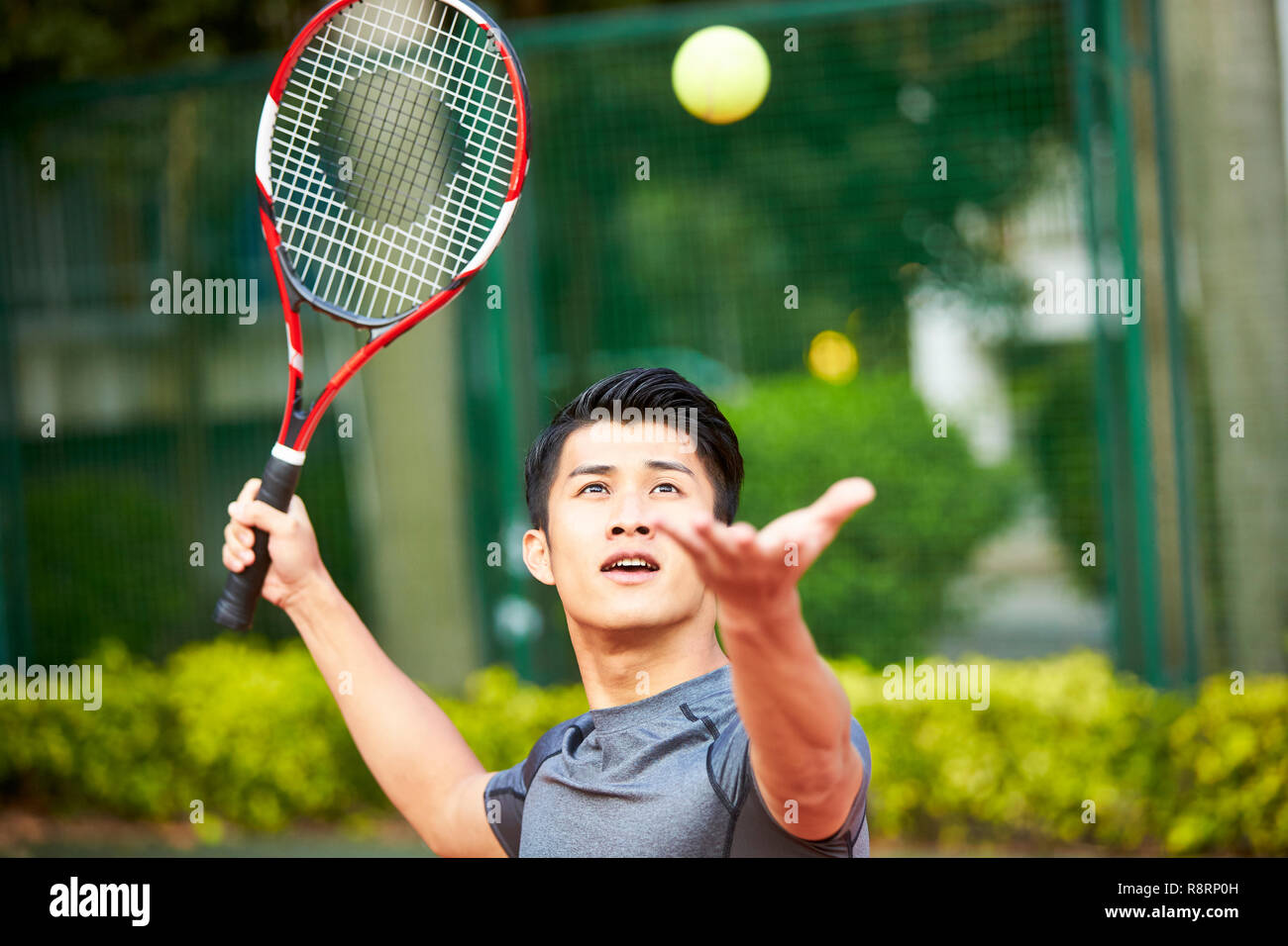 Jungen asiatischen erwachsener Mann Tennis spielen Stockfoto