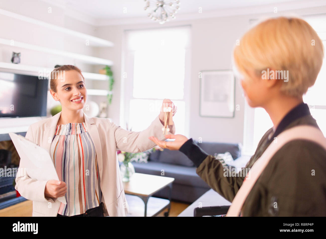 Immobilienmakler geben Schlüssel an die Frau in der Wohnung Stockfoto