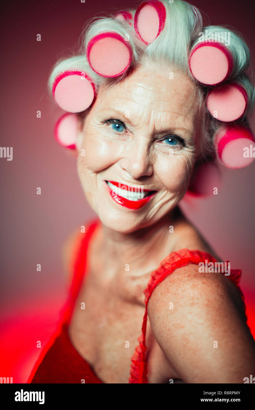 Porträt Lächeln, selbstbewusste ältere Frau mit Lockenwicklern im Haar Stockfoto