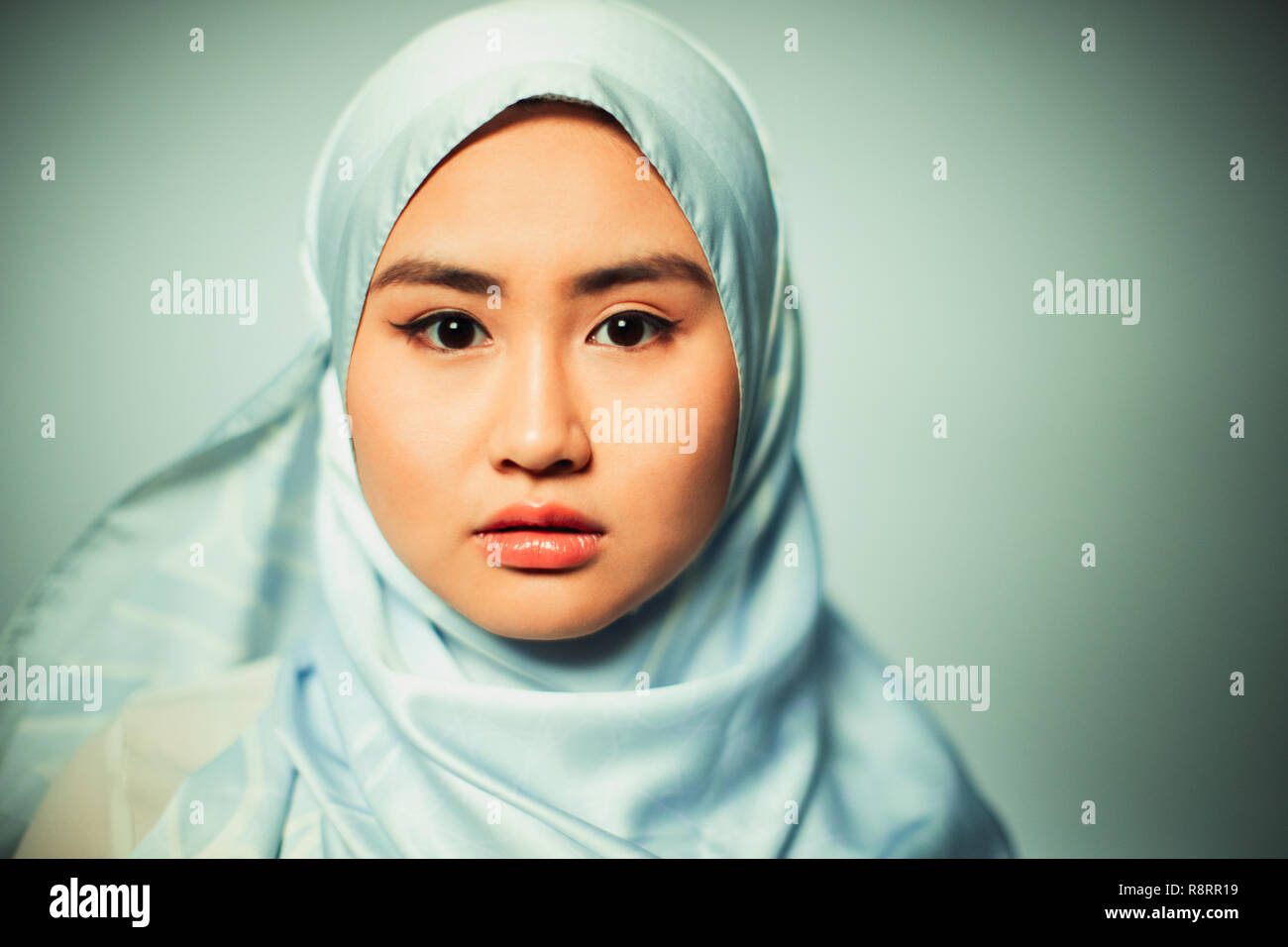 Portrait zuversichtlich, ernsthafte junge Frau trägt blaue Seide hijab Stockfoto