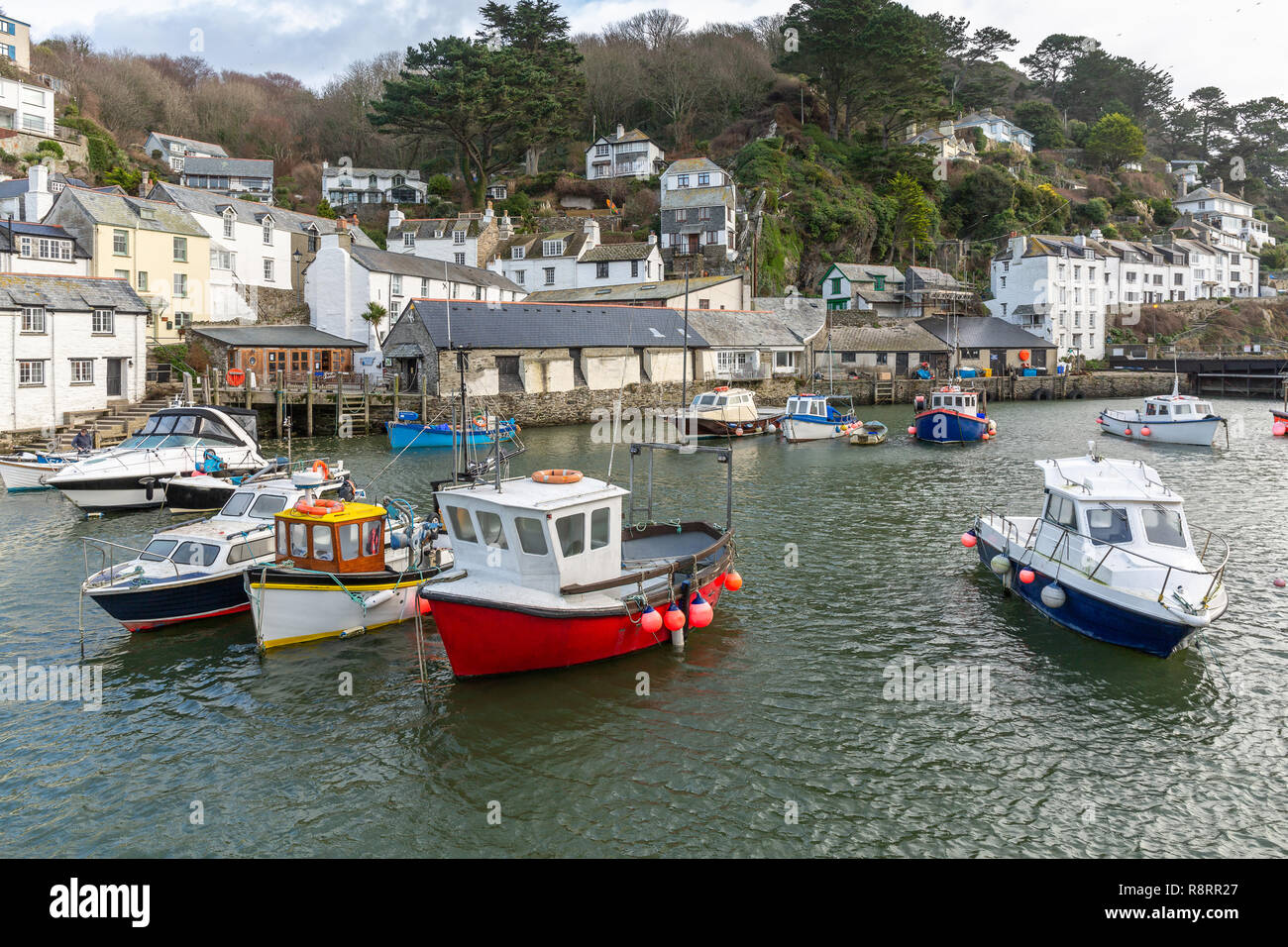 Blick auf den historischen Hafen in Polperro in Cornwall, mit Freizeit- und Fischerboote in verschiedenen Farben in den geschützten inneren Hafen. Stockfoto