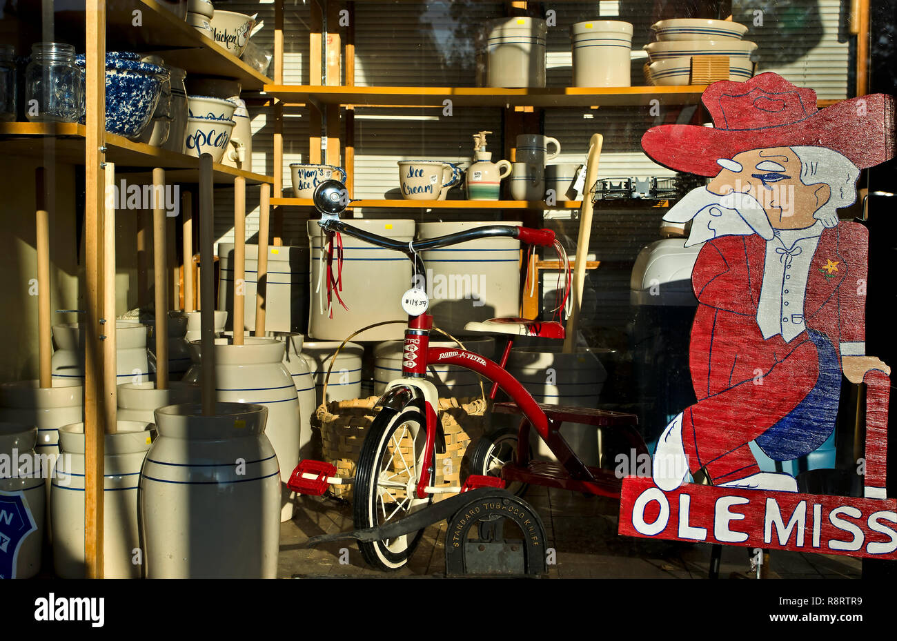 Ehemalige Ole Fräulein Maskottchen "Oberst Reb' beaufsichtigt ein Sortiment von Vintage Antiquitäten im Fenster Booker Hardware in Holly Springs, Mississippi. Stockfoto