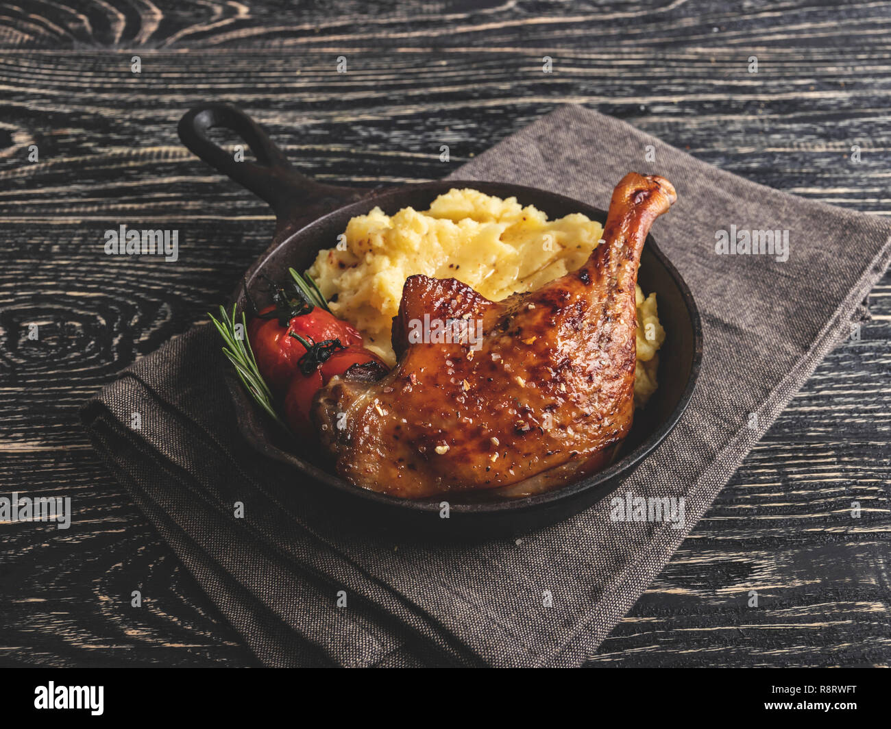 Saftig gegrillte Ente Bein mit Tomaten mit Kartoffelpüree in einer Umhüllung pan Stockfoto