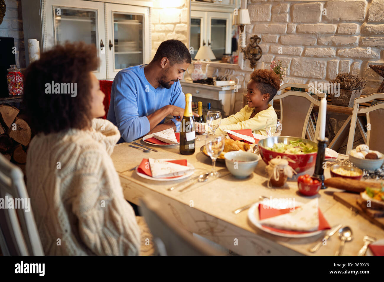 Lustige Familie beim Abendessen zu Hause am Heiligabend. Winterurlaub