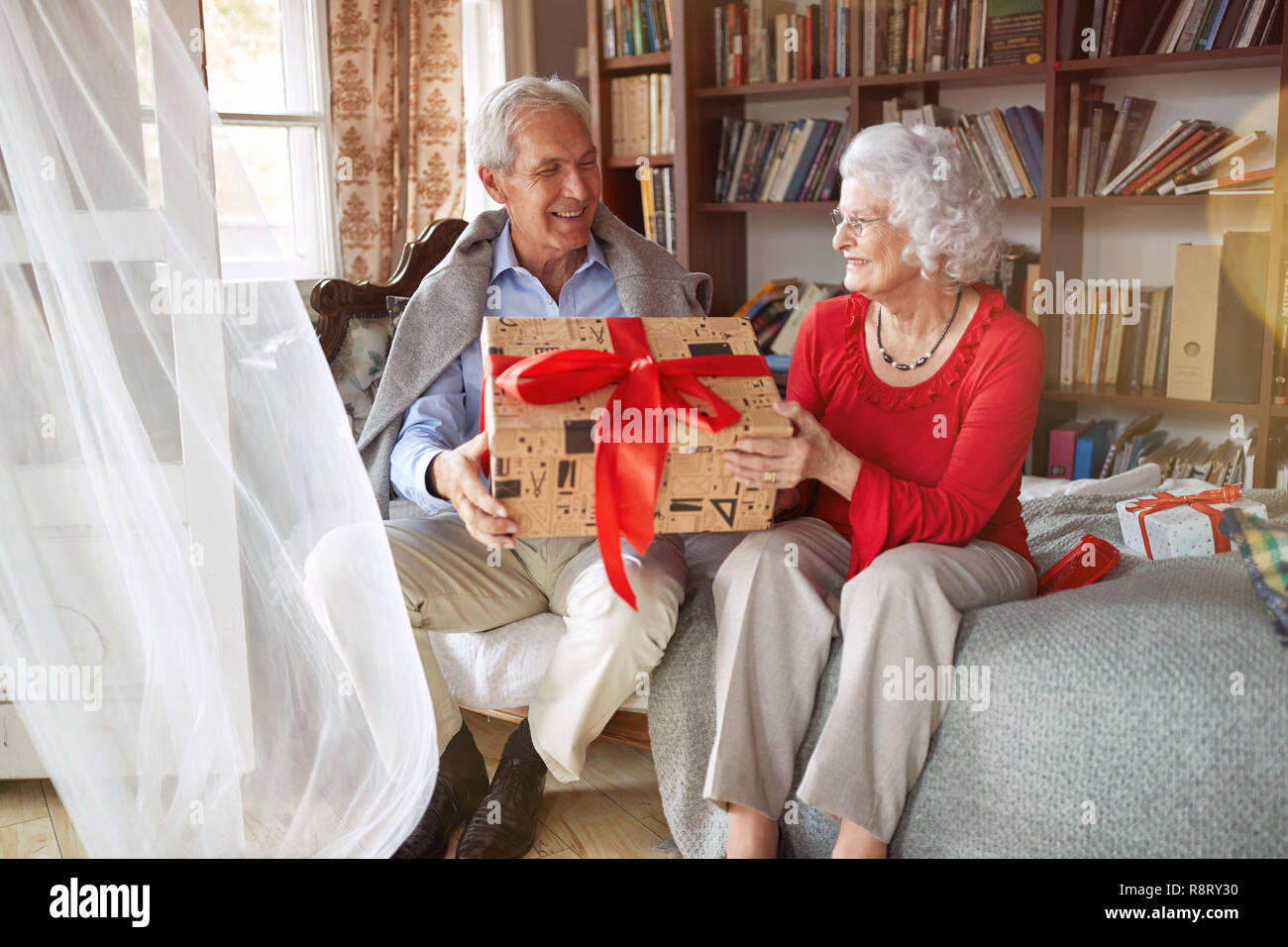 Schönes älteres Paar ihre Weihnachtsgeschenke austauschen zu Hause Stockfoto