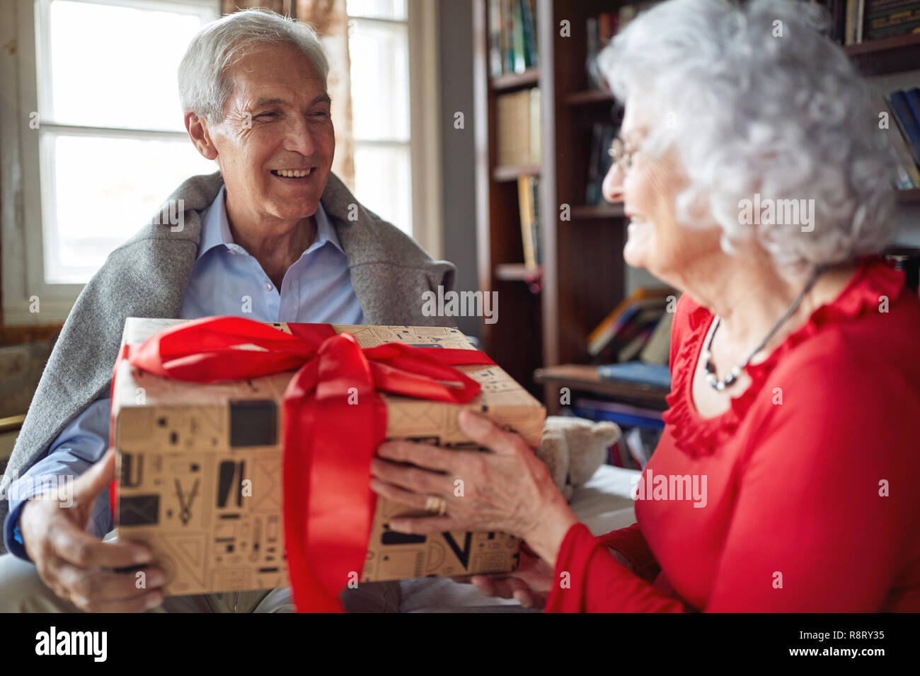 Lächelnd Senior Paar ihre Weihnachtsgeschenke austauschen zu Hause Stockfoto