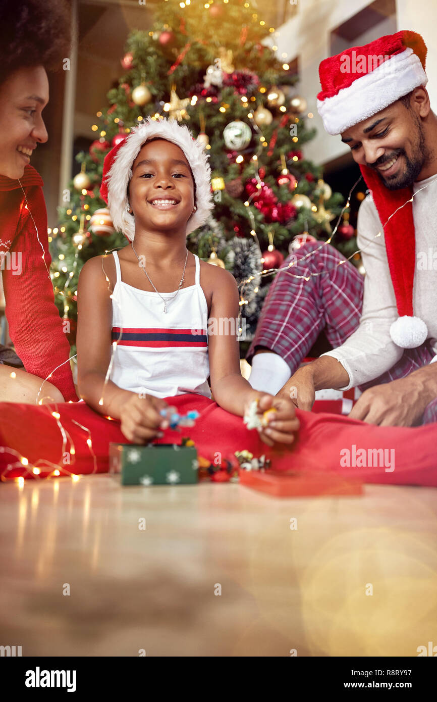 Happy Family vor geschmückten Weihnachtsbaum zu Hause Stockfoto