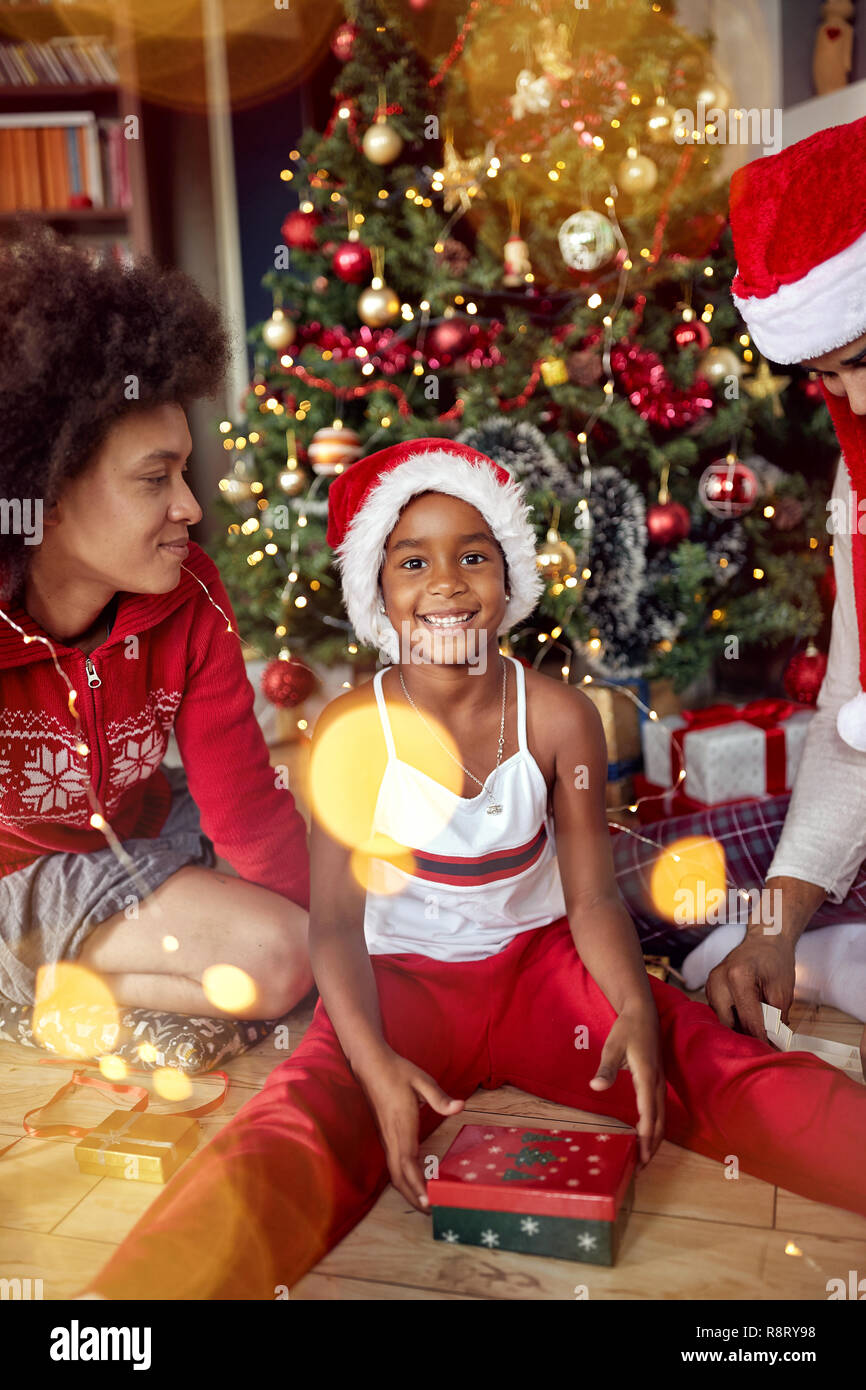 Happy Family - süße Mädchen öffnet ein Geschenk für Weihnachten Morgen Stockfoto