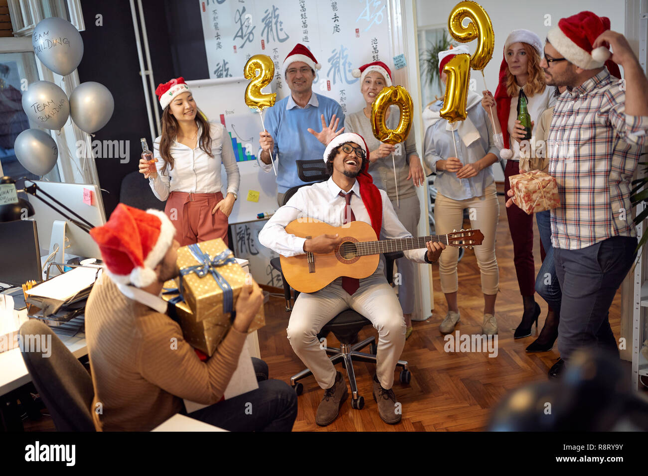 Happy Business Team Spaß haben und tanzen in Santa Hut auf Xmas Party im Büro Stockfoto