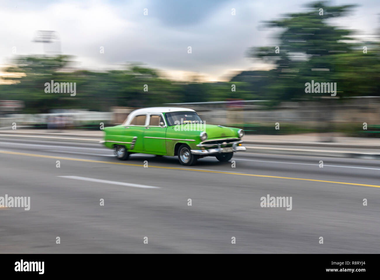 Iconic alten grünen amerikanisches Auto beschleunigt, entlang des Malecón in Havanna, Kuba Stockfoto