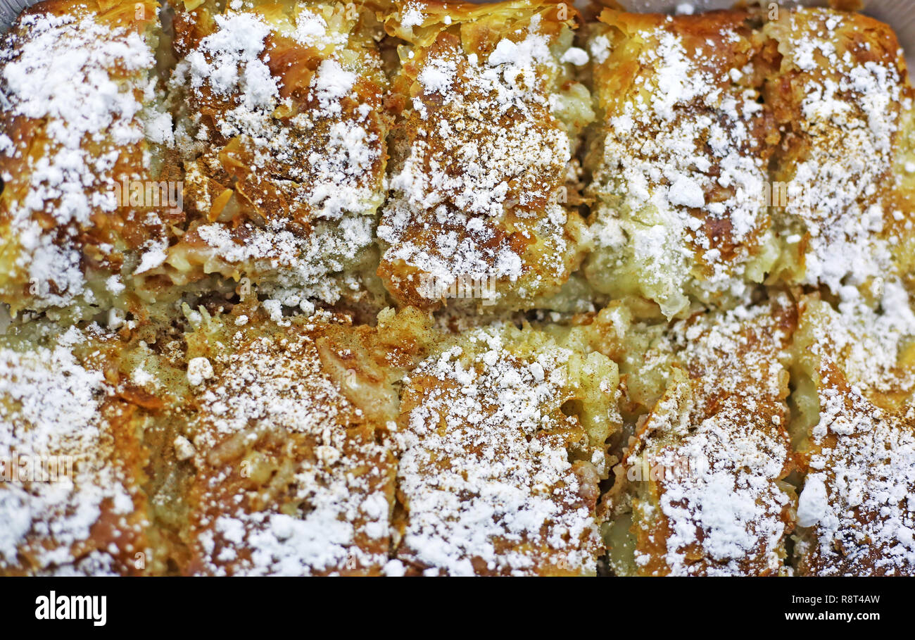 Traditionelle griechische bougatsa - griescreme Gebäck mit Sahne gefüllt und mit Puderzucker und Zimt garniert Stockfoto