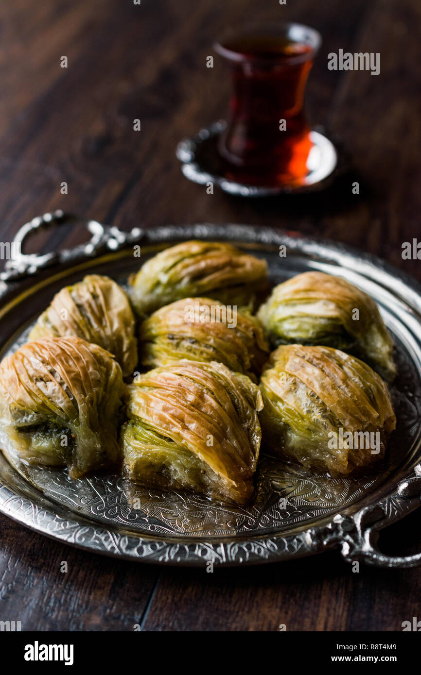 Türkische Midye Baklava (Muschel Form Baklawa) mit grünen Pistazien Pulver, Butter, Sahne und traditionelle Kaffee in Silber Fach. Dessert mit Pistazien Stockfoto