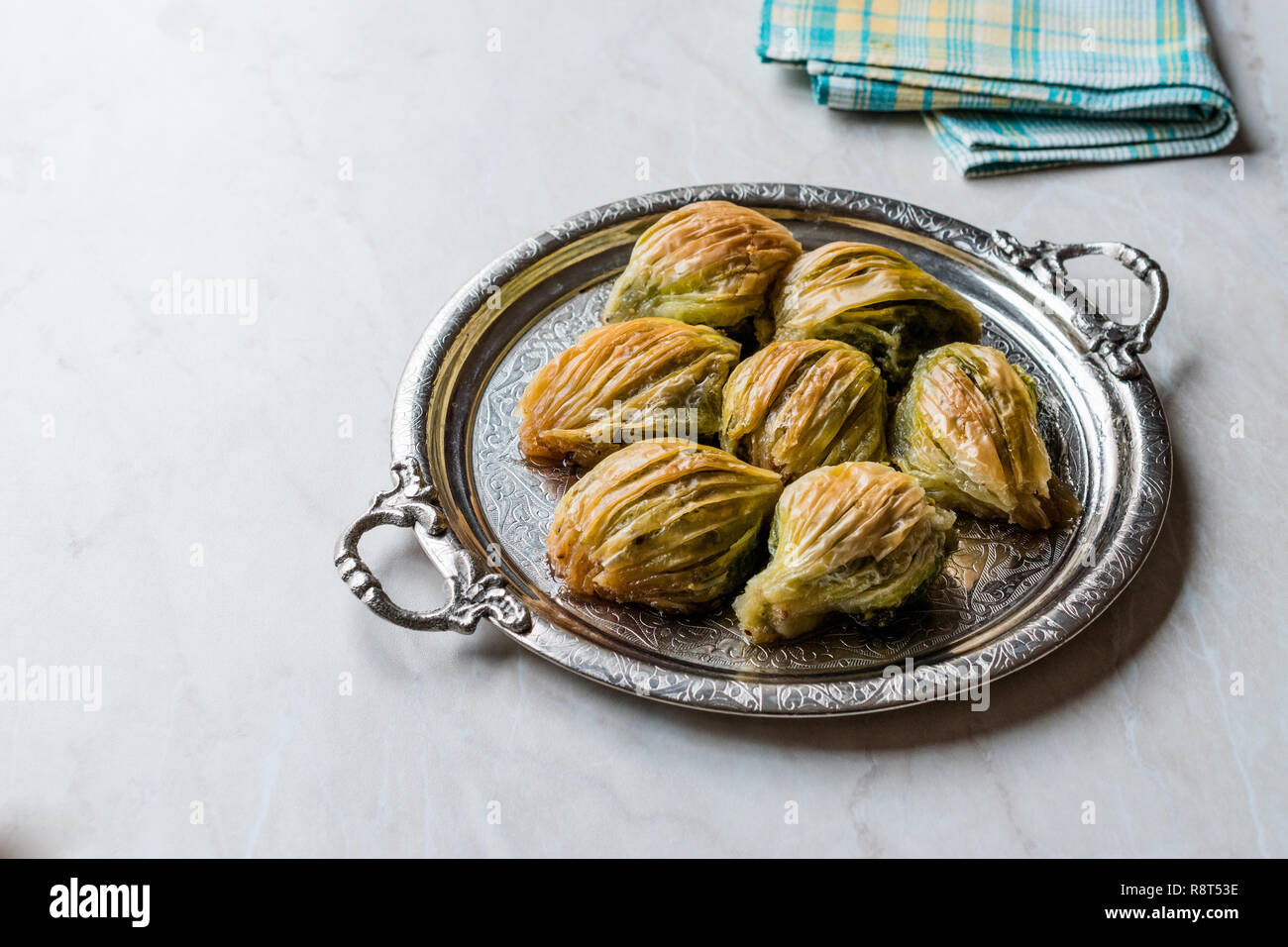 Türkische Midye Baklava (Muschel Form Baklawa) mit grünen Pistazien und Butter Creme in Silber Fach. Dessert mit Pistazien Stockfoto