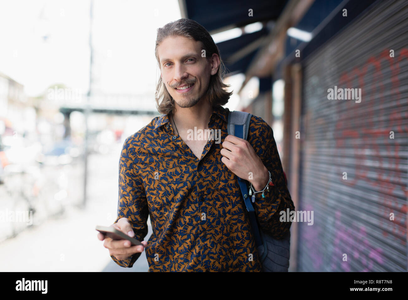 Portrait zuversichtlich hipster Mann mit Smart Phone auf städtischen Bürgersteig Stockfoto