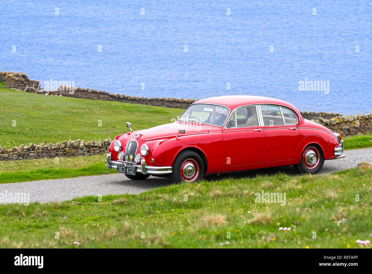 Rot 1962 Jaguar Mk 2/Jaguar Mk II 3,8 Liter klassische Sportwagen entlang der Küstenstraße fahren Stockfoto