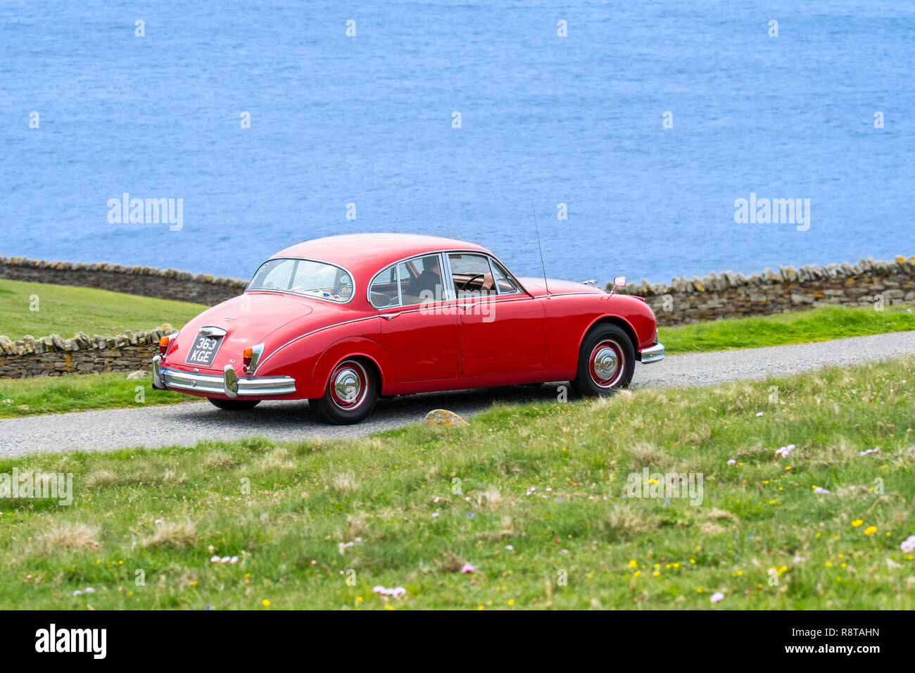 Rot 1962 Jaguar Mk 2/Jaguar Mk II 3,8 Liter klassische Sportwagen entlang der Küstenstraße fahren Stockfoto