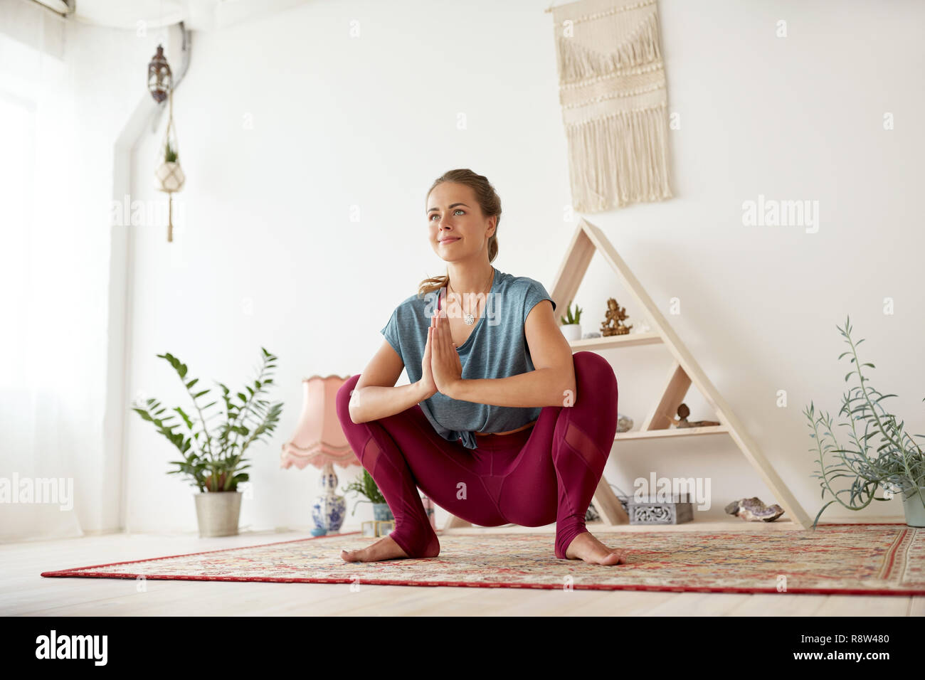 Junge Frau tun Garland bei Yoga Studio darstellen Stockfoto
