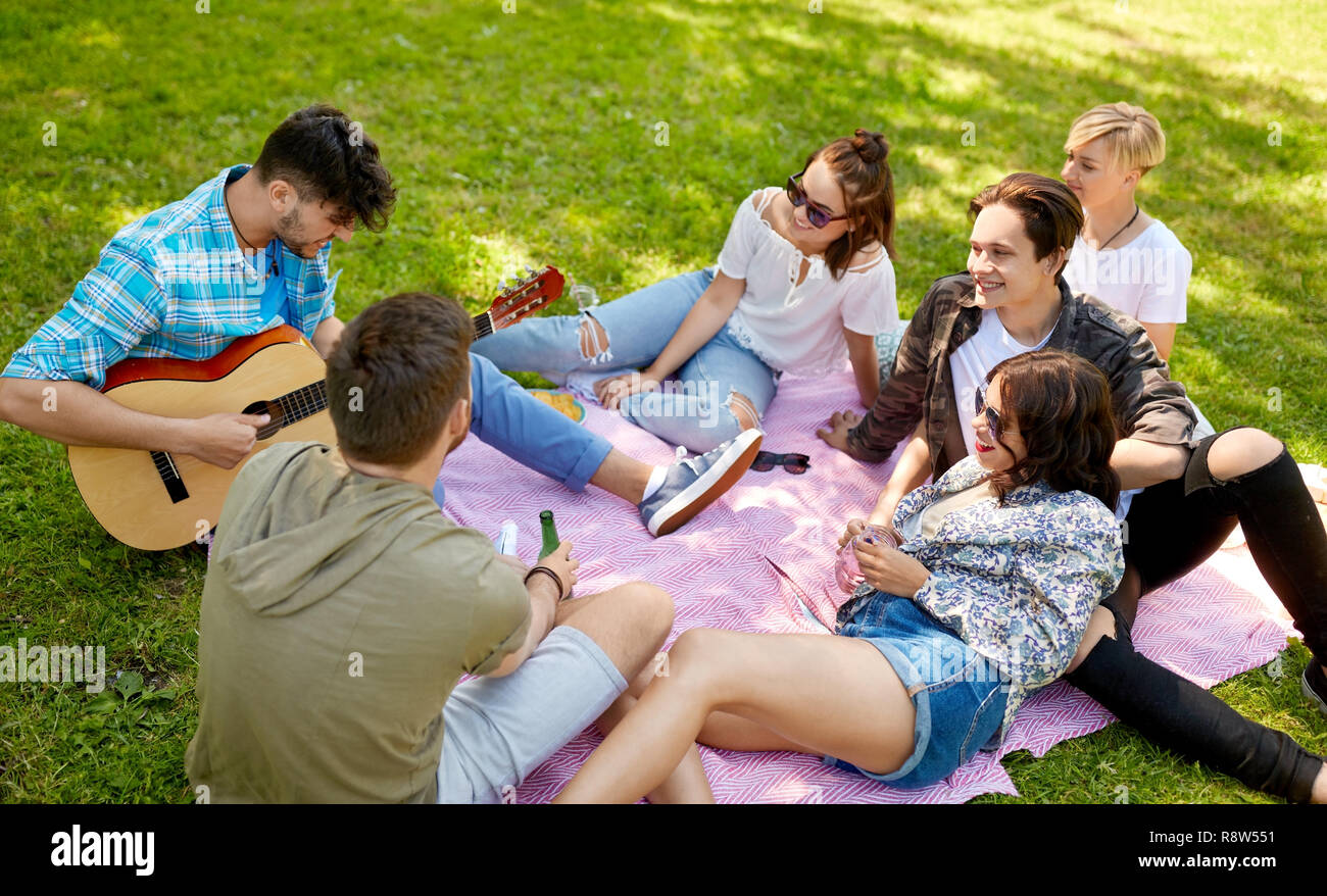Freunde Gitarre zu spielen, Picknick im Sommer Park Stockfoto