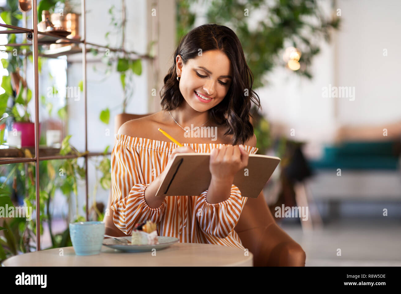 Frau mit einem Notebook, das im Coffee Shop oder Café Stockfoto