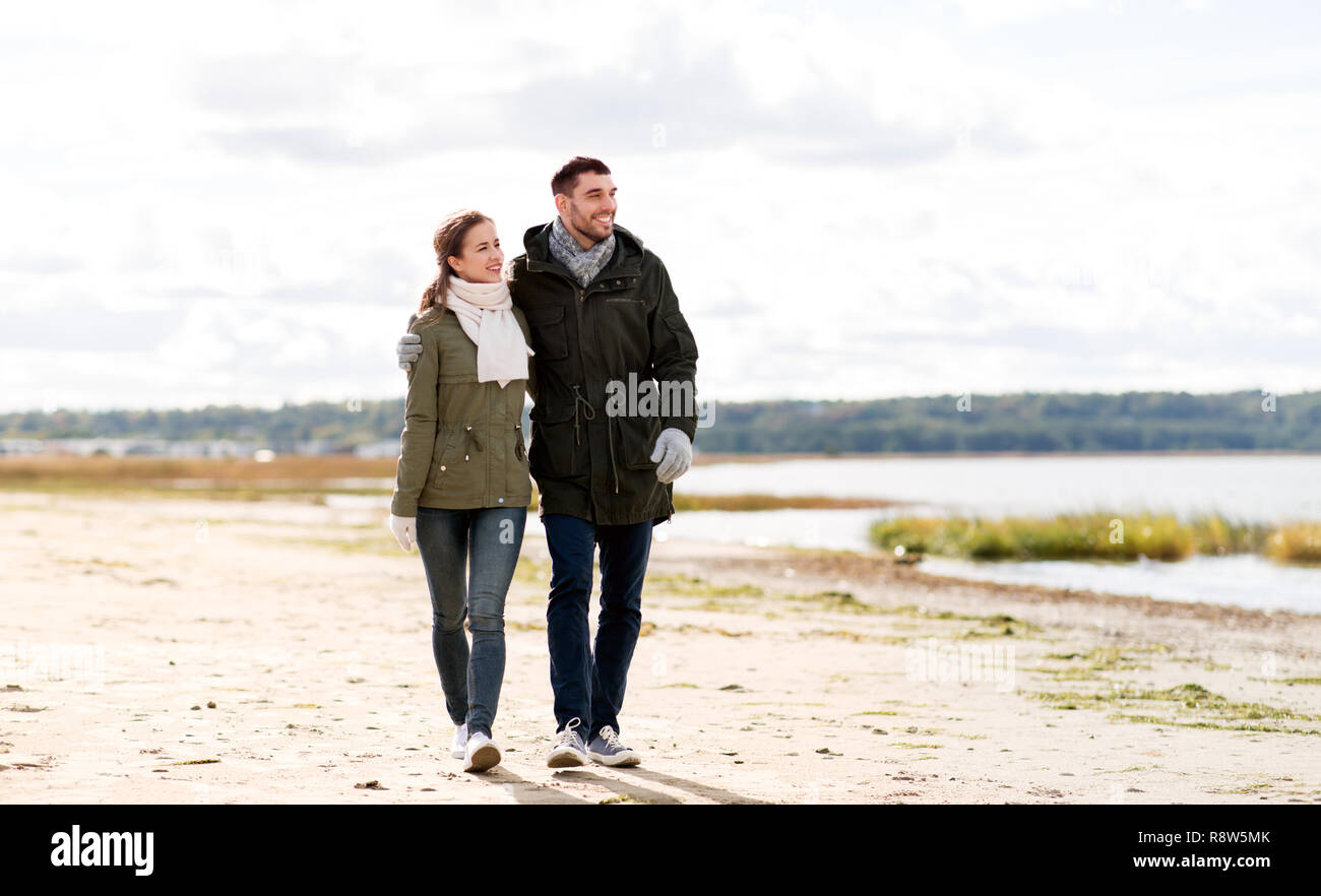 Paar entlang Herbst Strand Stockfoto