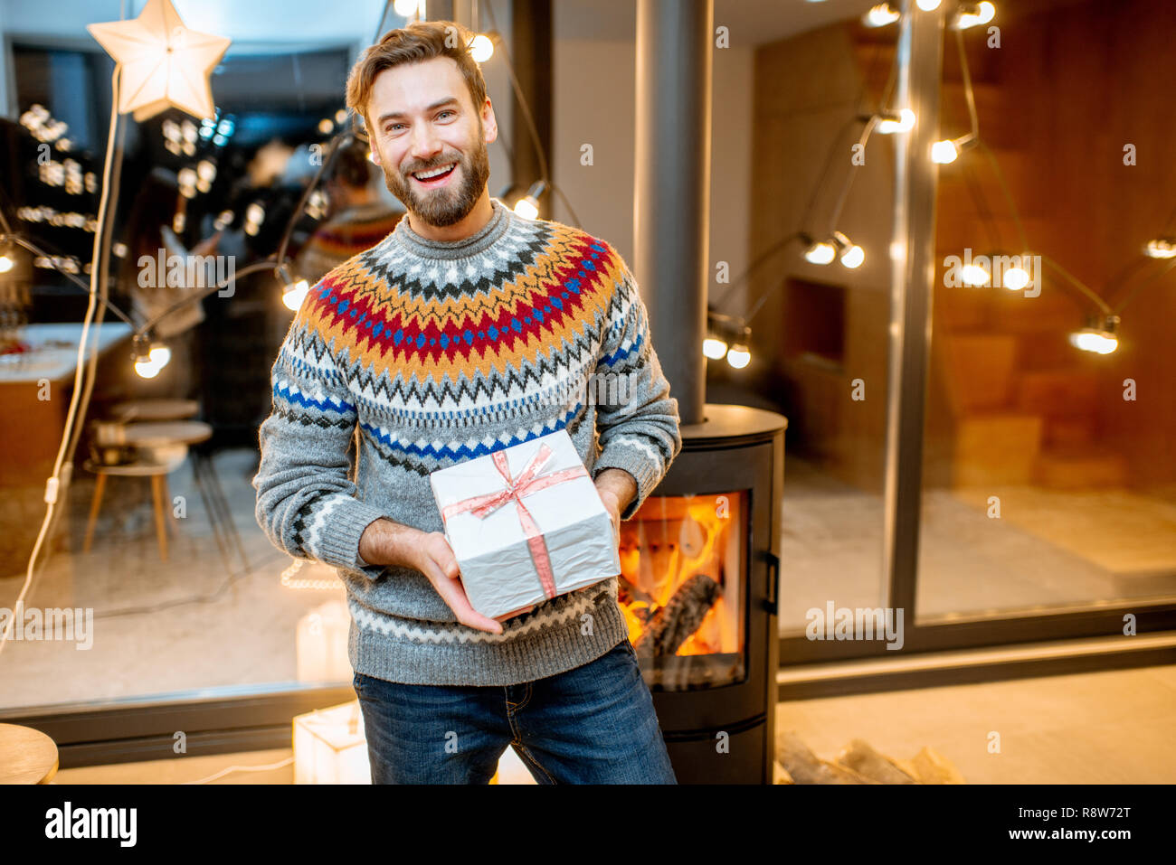 Porträt von einem gutaussehenden Mann mit Geschenkbox im Winter Urlaub zu Hause Stockfoto