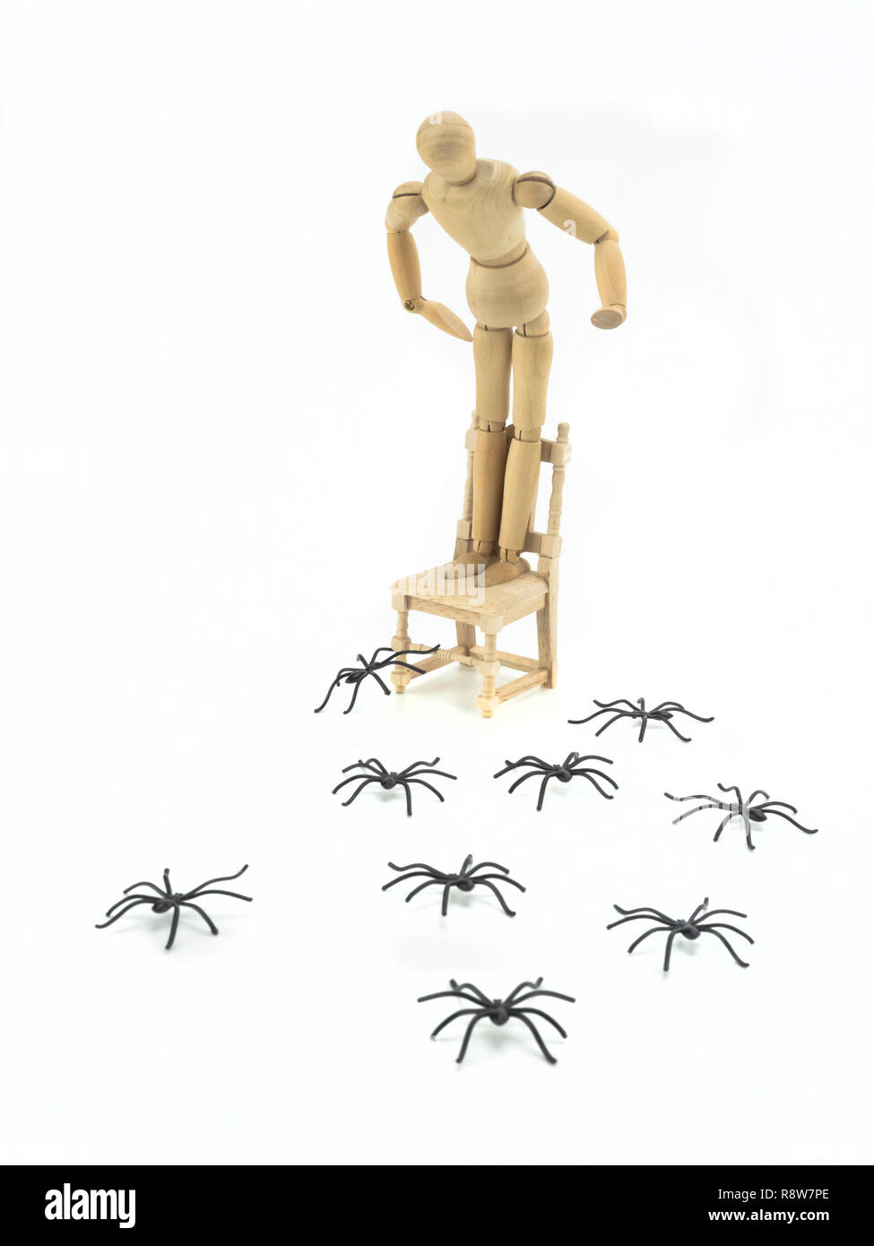 Holzpuppe hochgeladen Stuhl mit spider Phobia, konzeptionelle Bild Stockfoto