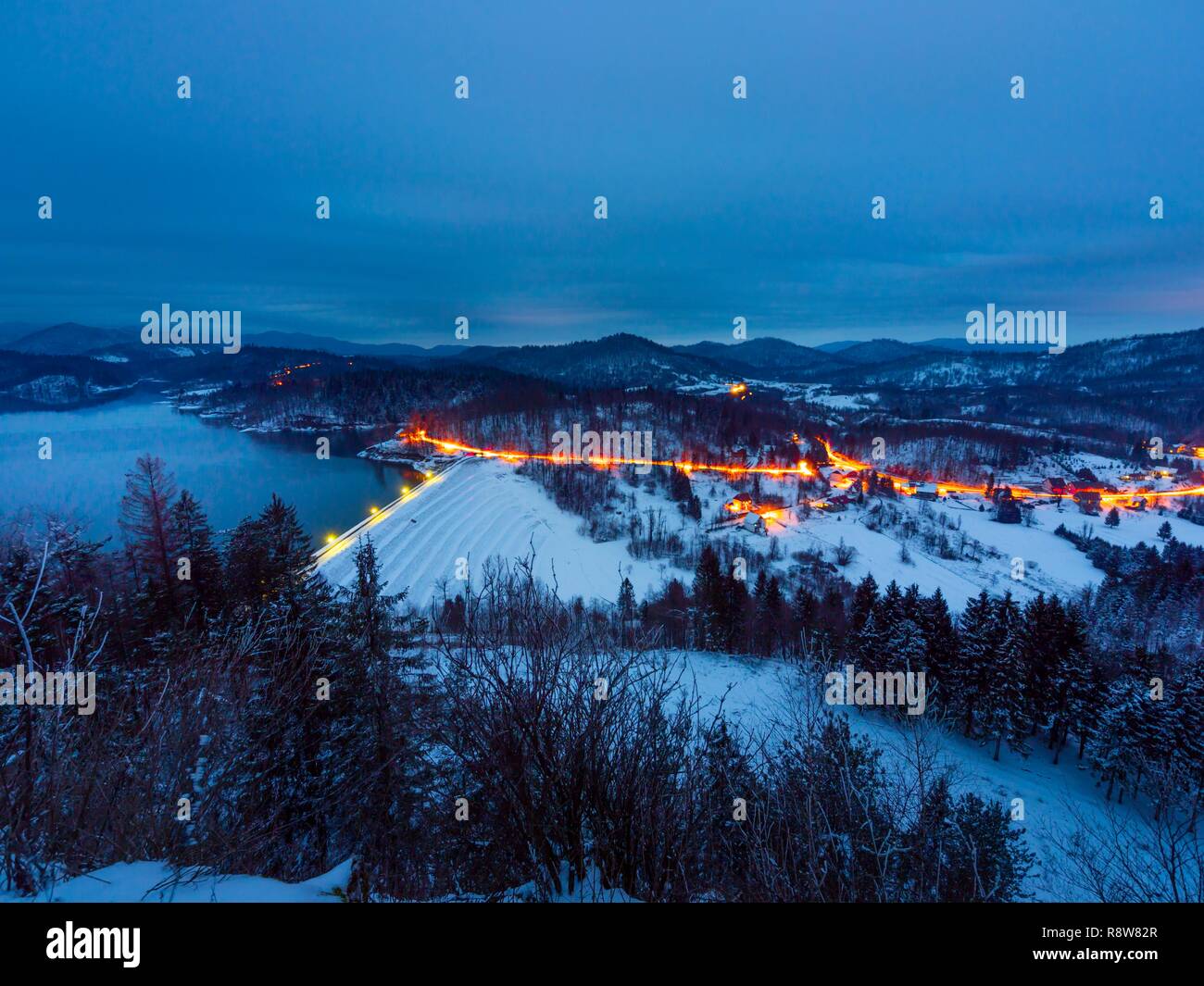 Lokve Stadt In Kroatien Im Winter Unter Schnee Abend Beleuchtung Von Hausern Und Reisen Fahrzeug Auf Der Strasse Lokva See Und Damm Lokvarsko Jezero Stockfotografie Alamy