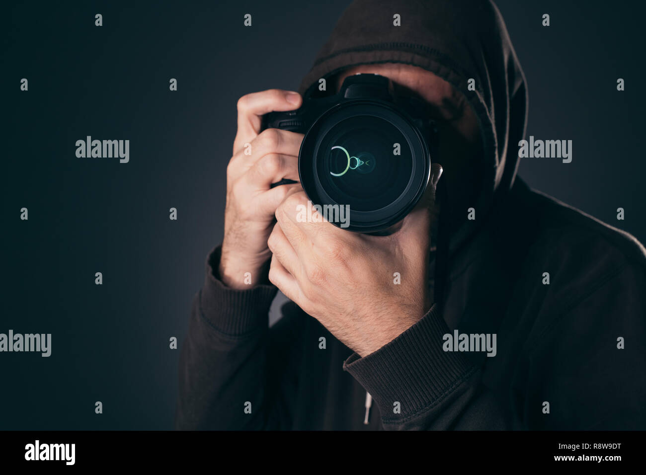 Hooded Fotograf hinter DSLR-Kamera, Low Key portrait Stockfoto