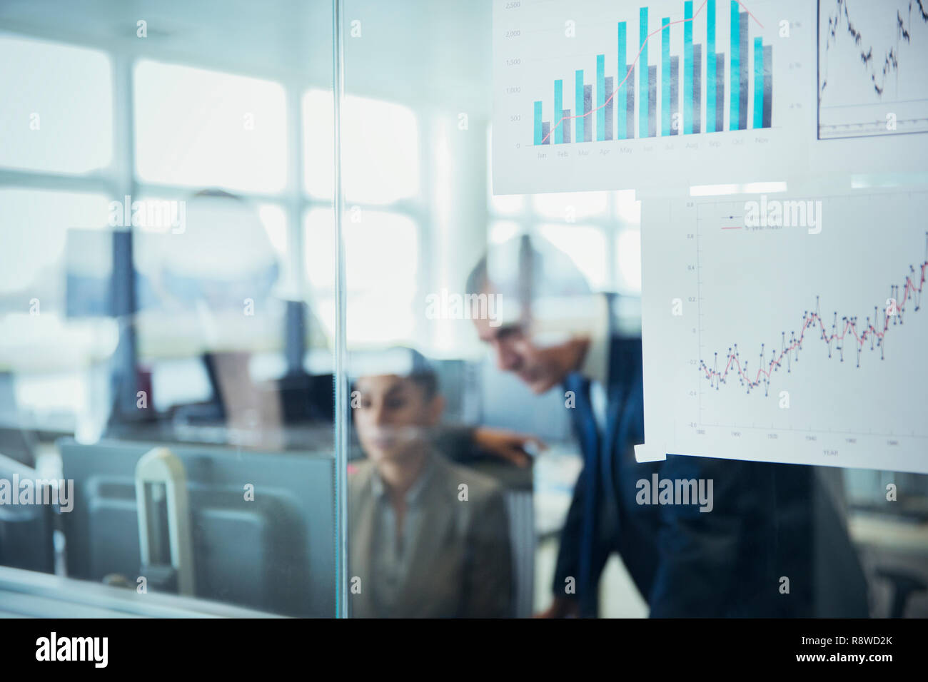 Geschäftsleute können Sie über Computer hinter Diagramme und Diagramme in Office Stockfoto