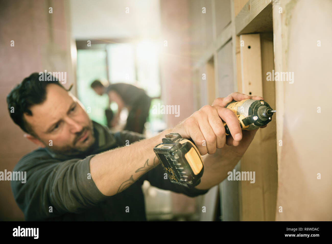 Bauarbeiter mit Bohrmaschine ausgerichtet Stockfoto
