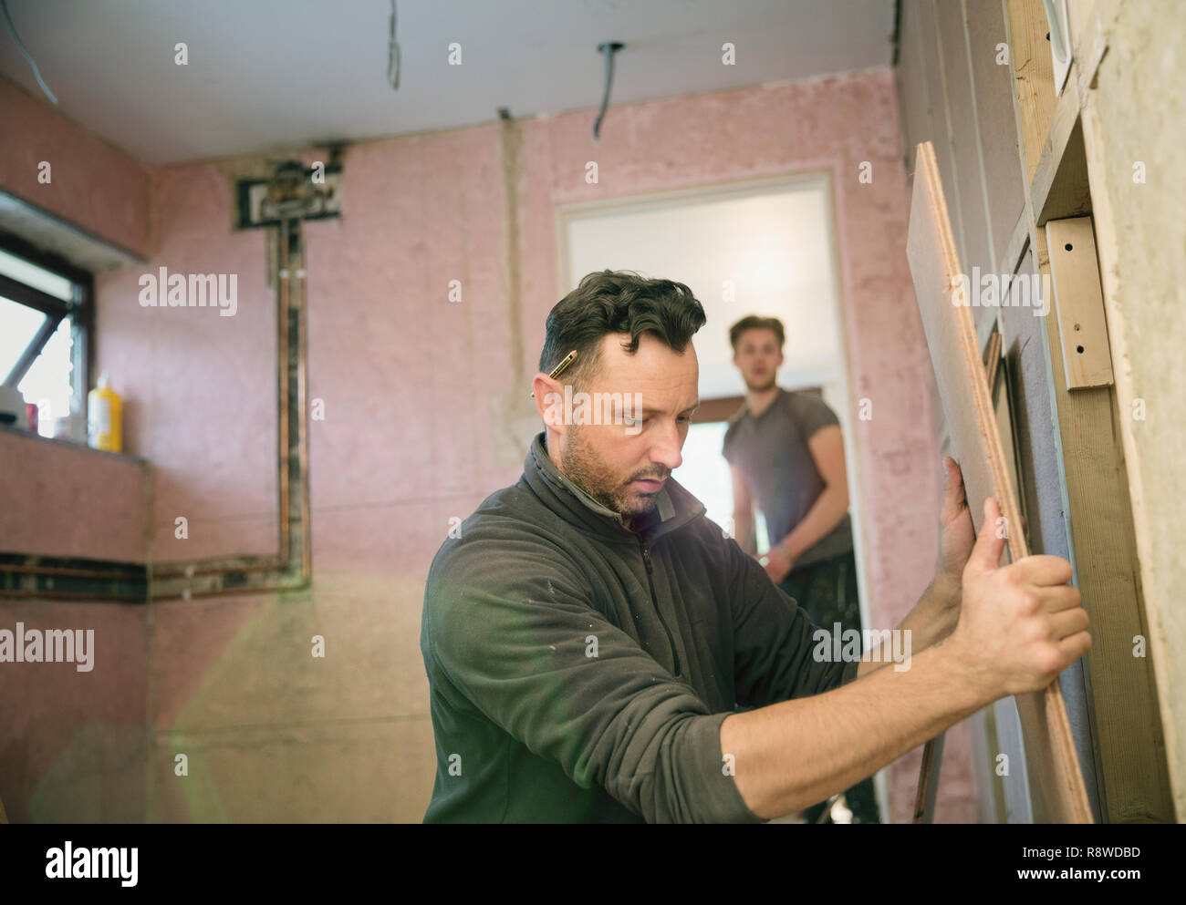Bauarbeiter holding Holzbrett, Framing Haus Stockfoto