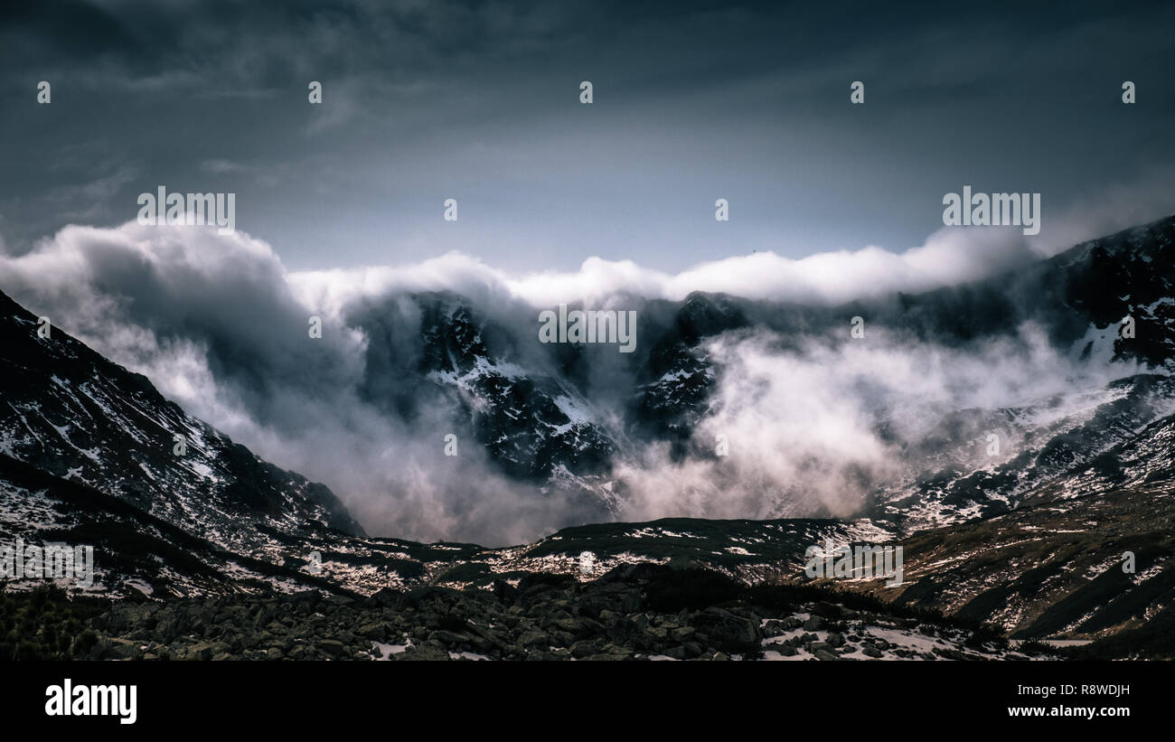 Wolken Verschütten über einen Bergrücken Stockfoto