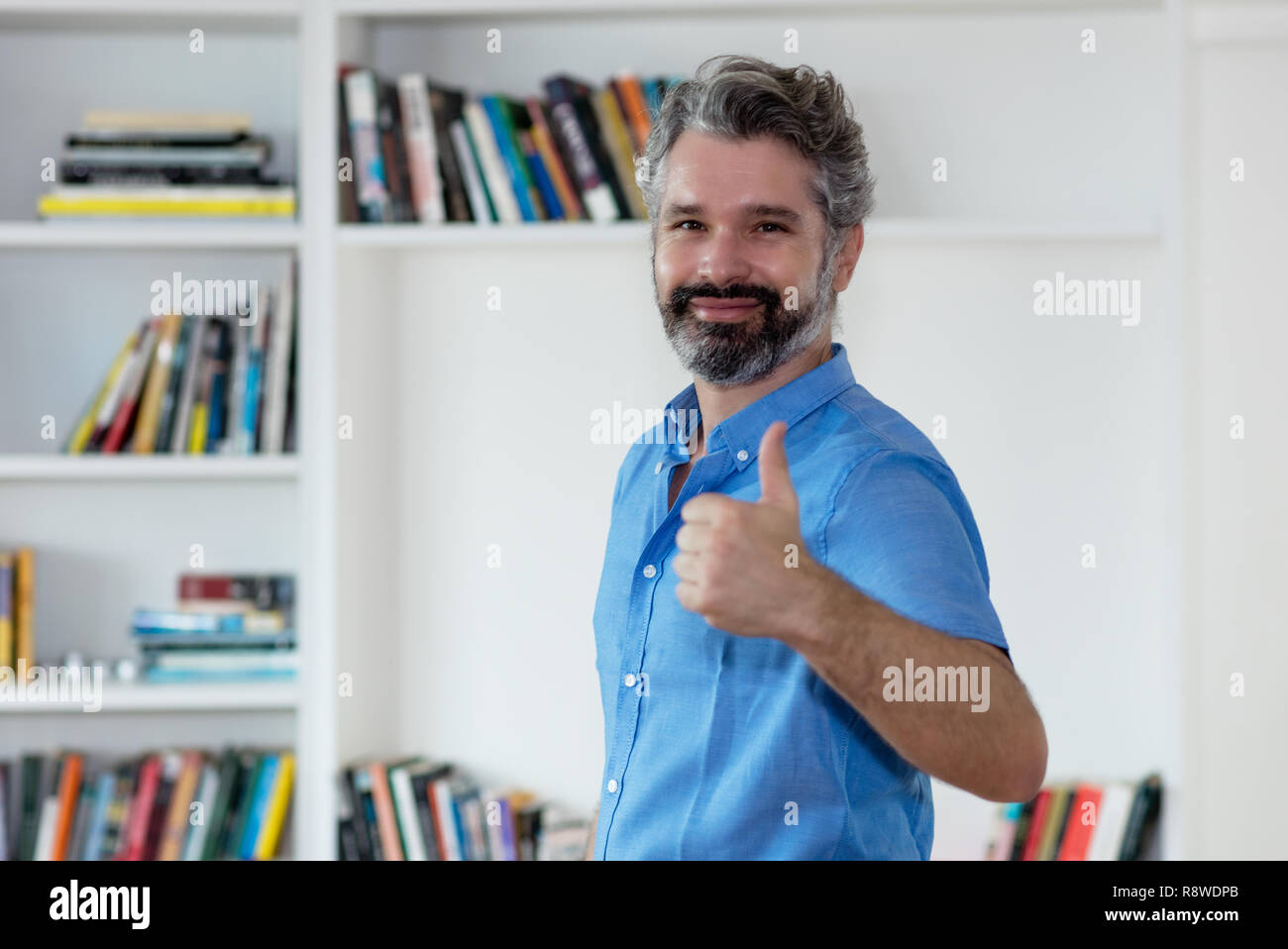 Erfolgreich im Mittleren alter Mann mit grauen Haaren indoor zu Hause Stockfoto