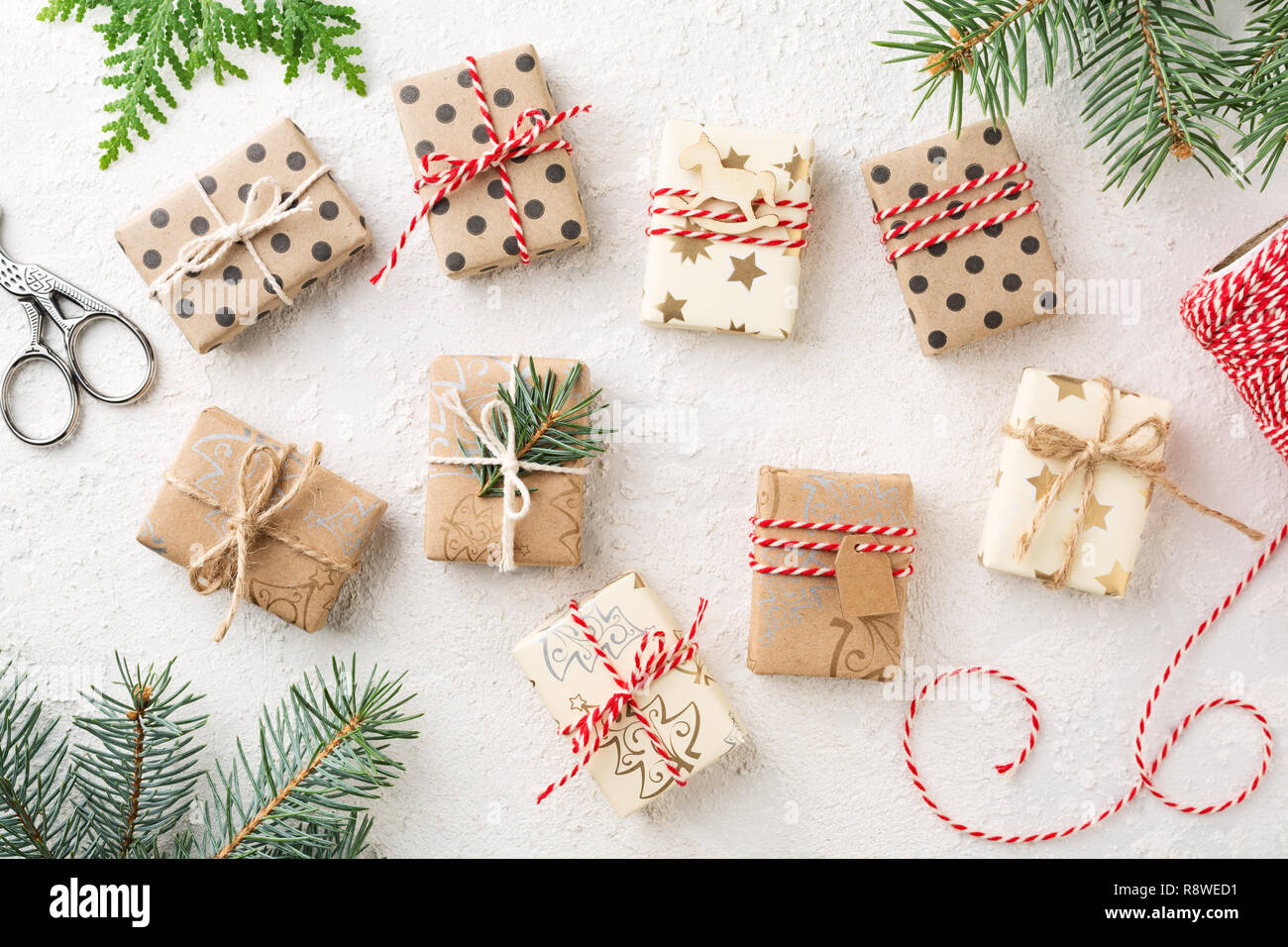 Viele Weihnachten Geschenkboxen, Bäcker Garn & Fichte auf weißer Tisch. Eingepackte Geschenke braun Kraftpapier. Weihnachten Vorbereitung. Stockfoto